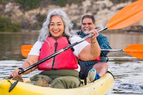 Two friends rowing a boat together outdoors